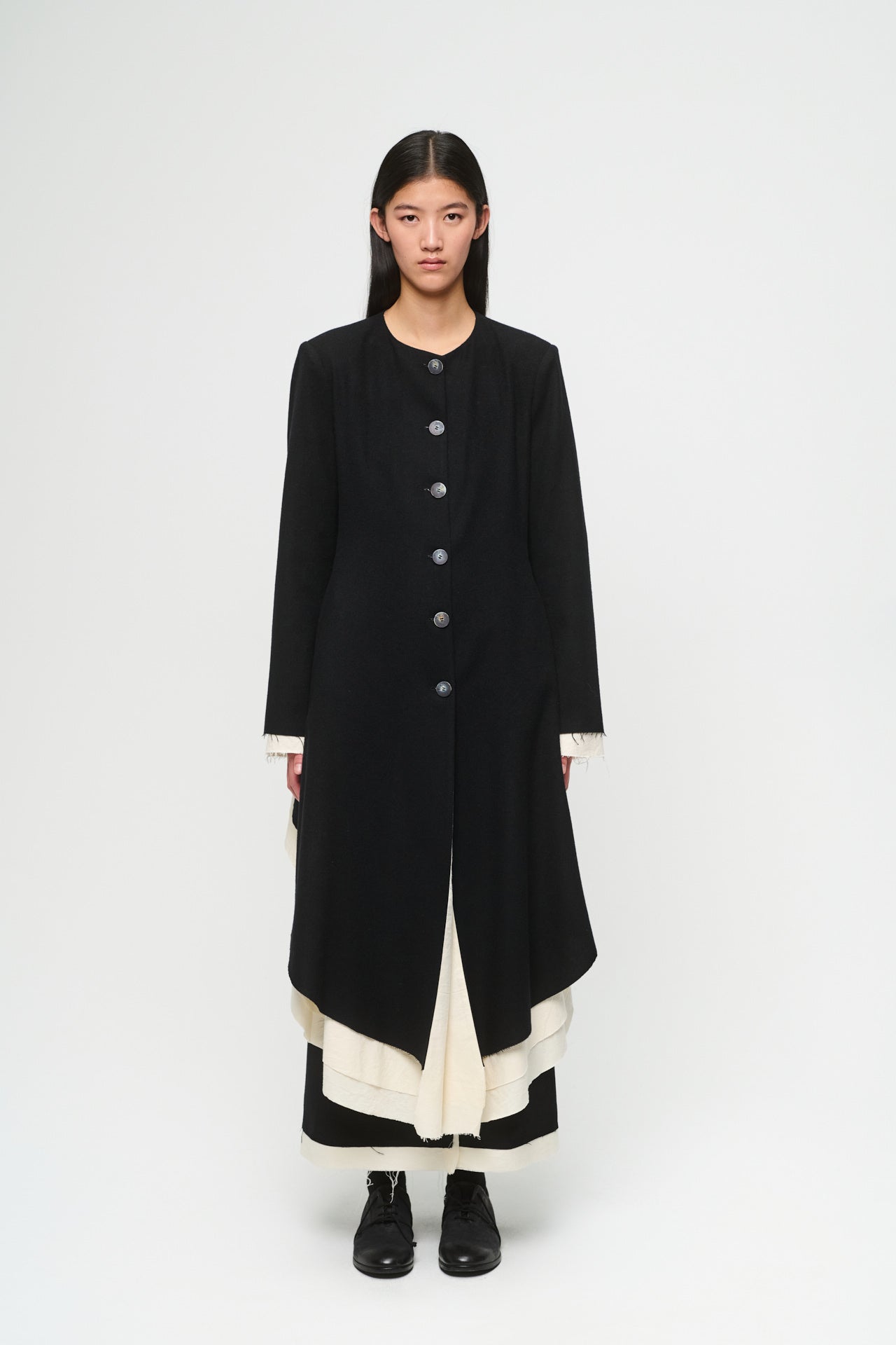 Person wearing a black and white outfit on a white background