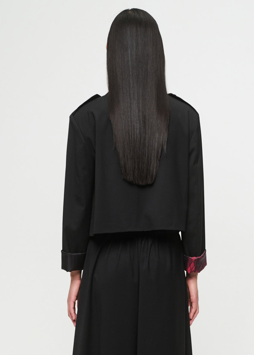 Woman wearing a black outfit with a plain background