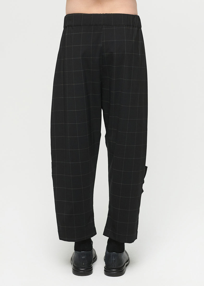 Black checkered pants worn by a person on a white background