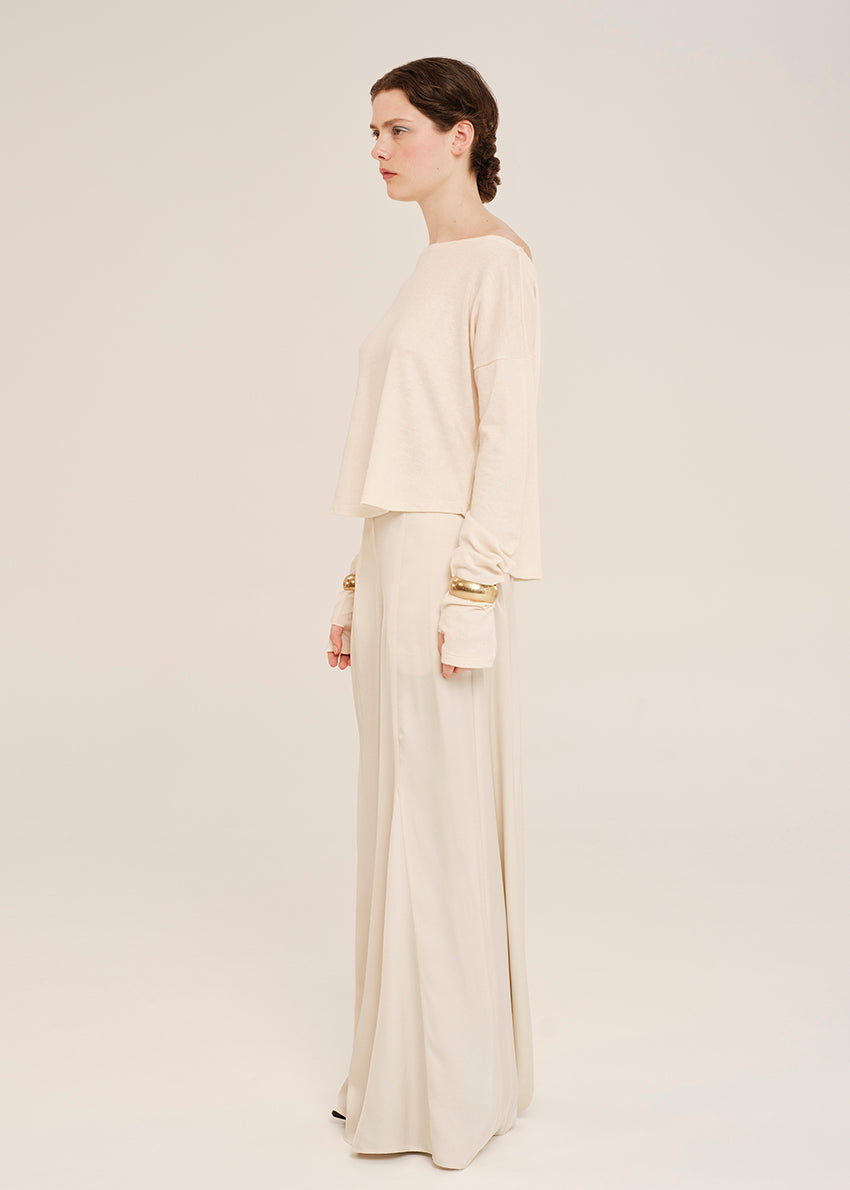 Woman wearing a beige outfit on a plain background