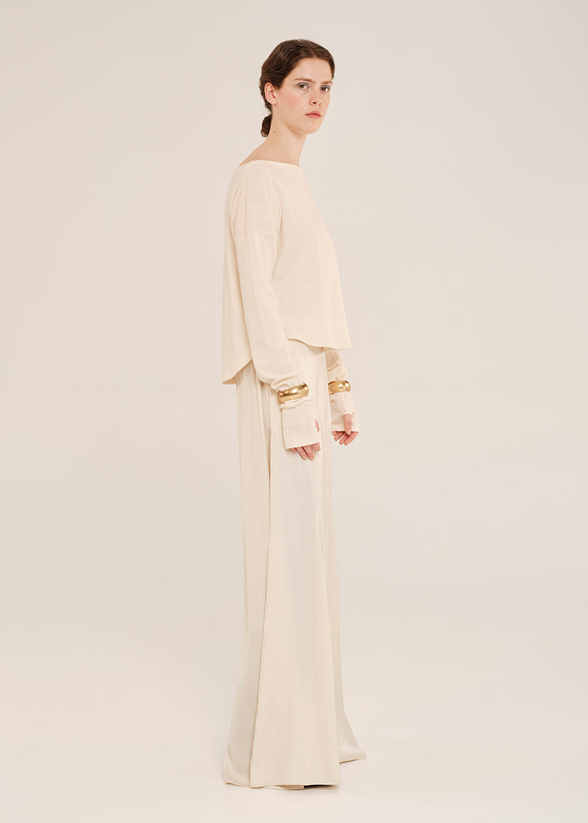 Woman wearing a beige outfit on a plain background