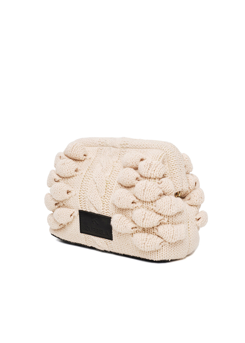 Knitted beige hat with pom-poms on a white background