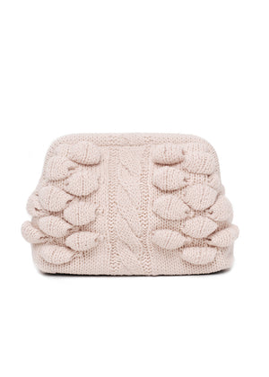 Knitted pouch with cable pattern and pom-poms on a white background
