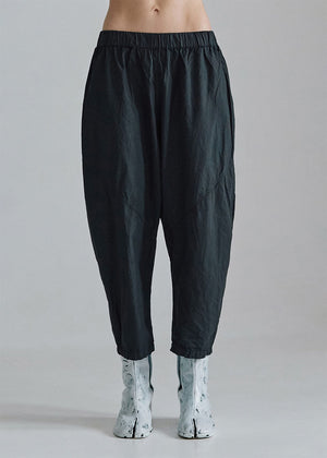 Cropped, drop-crotch unisex trousers, made from cotton poplin, in relaxed cut. These pants have an elastic waistband and diagonal seams just above the knee.