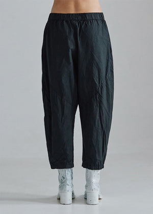 Cropped, drop-crotch unisex trousers, made from cotton poplin, in relaxed cut. These pants have an elastic waistband and diagonal seams just above the knee.