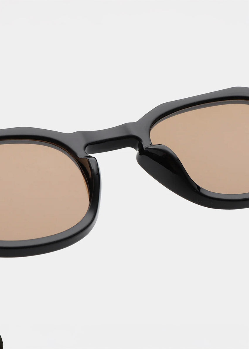 Black sunglasses with beige lenses on a white background