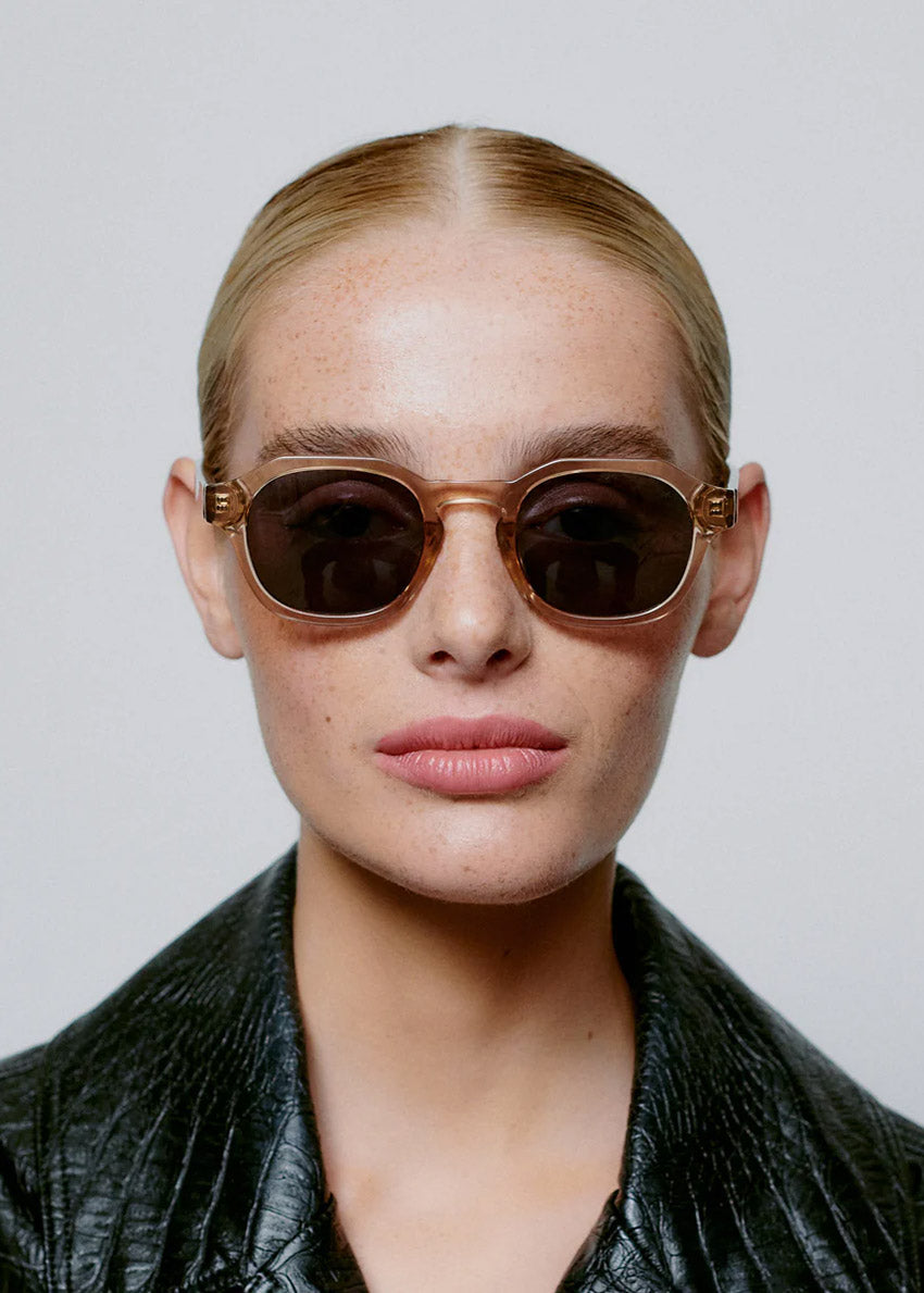 Sunglasses with a tortoiseshell frame and dark lenses on a white background
