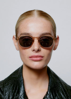Woman wearing sunglasses with a plain background