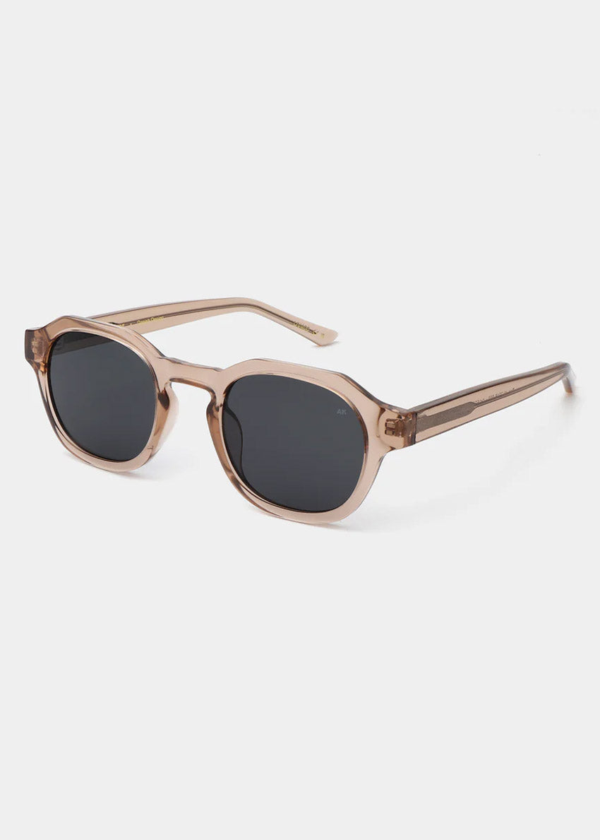 Sunglasses with a champagne frame and dark lenses on a white background
