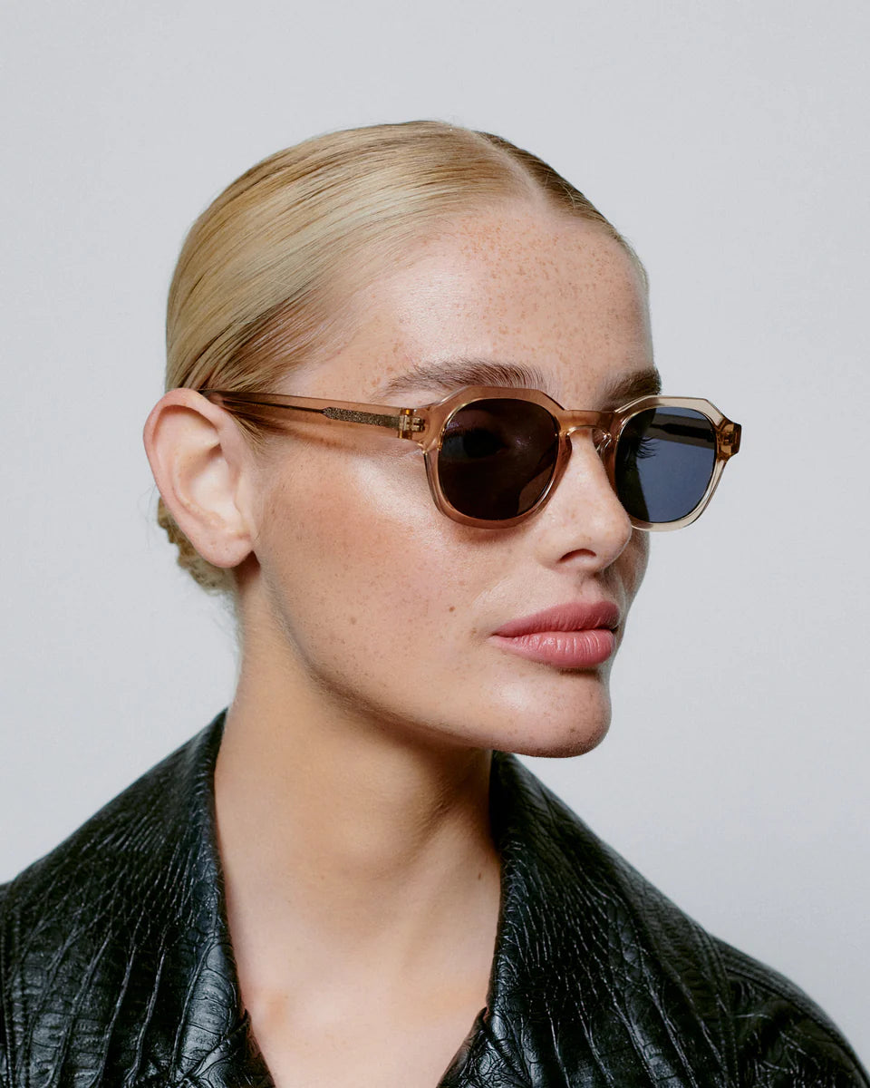 Woman wearing sunglasses with a plain background