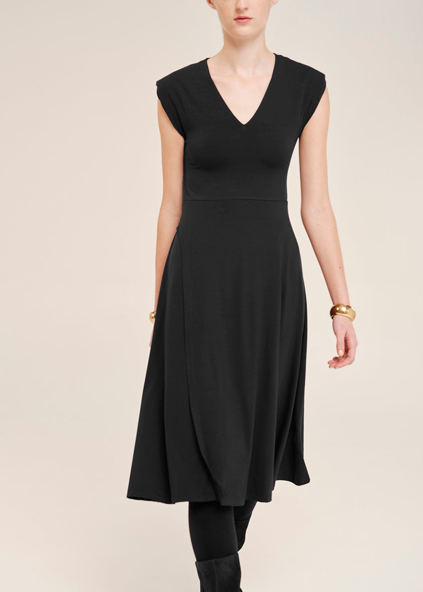 Black dress worn by a model on a plain background