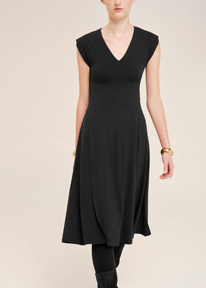 Black dress worn by a model on a plain background