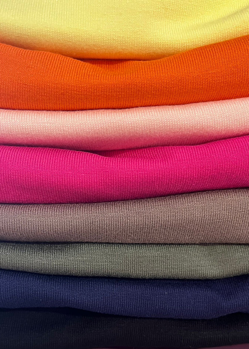 Stack of colorful folded fabric swatches in various colors.