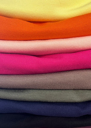 Stack of colorful folded fabric swatches in various colors.