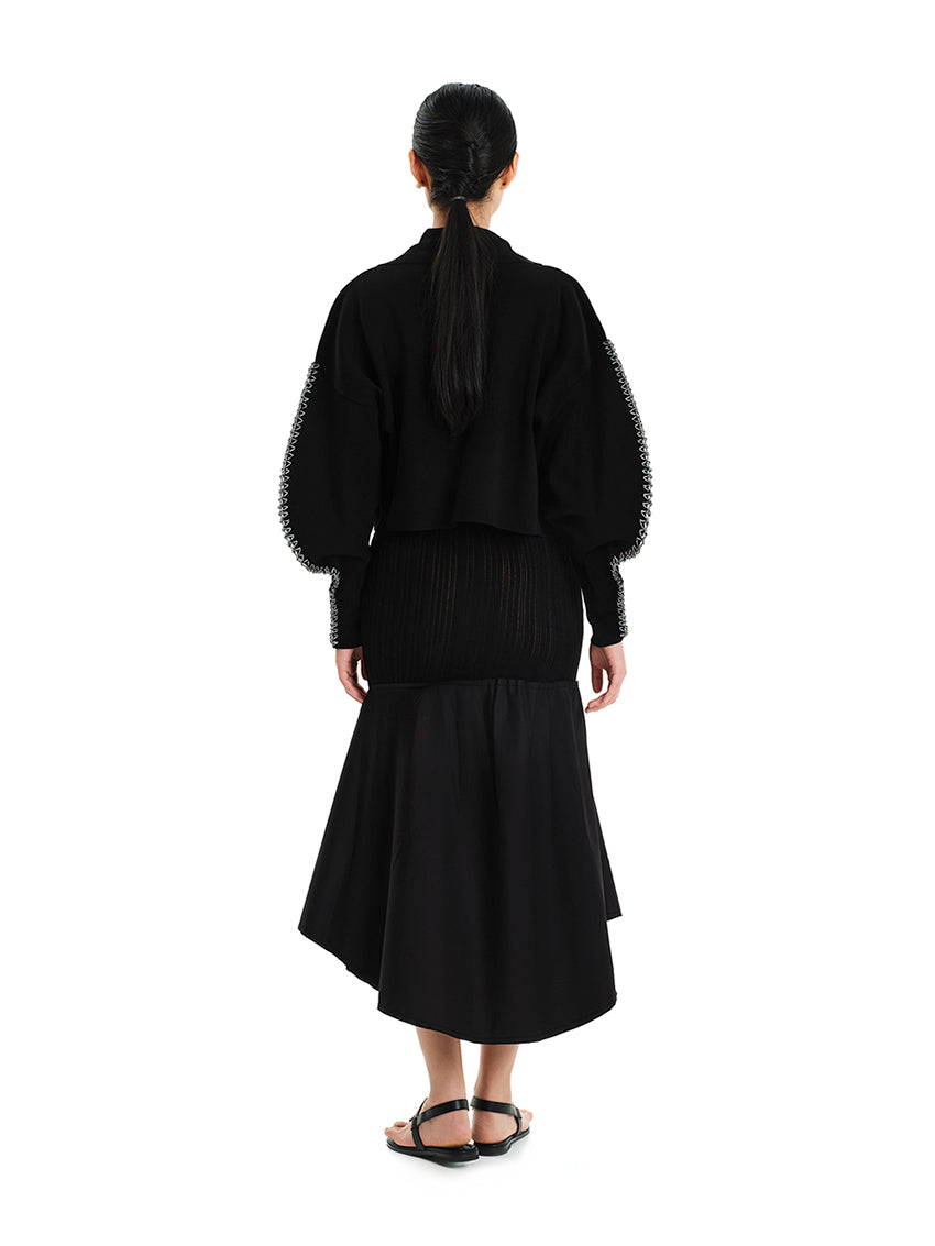 Cardigan with lapels and round sleeves made of elastic viscose yarn.Its dense knitting gives shape to the design while making the fit comfortable.It has long, round sleeves with details of embroidered yarn, adding a unique style to the garment