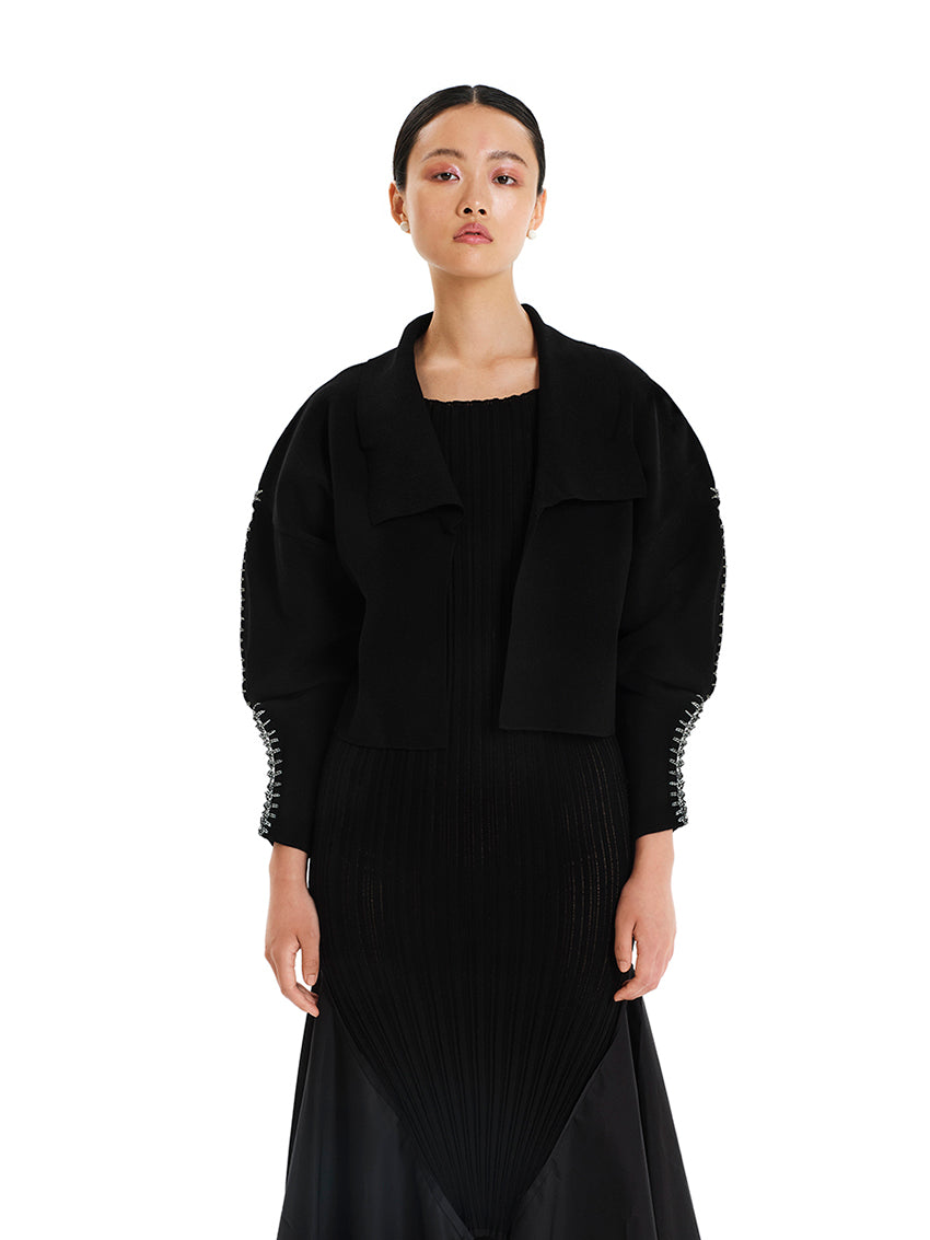 Cardigan with lapels and round sleeves made of elastic viscose yarn.Its dense knitting gives shape to the design while making the fit comfortable.It has long, round sleeves with details of embroidered yarn, adding a unique style to the garment