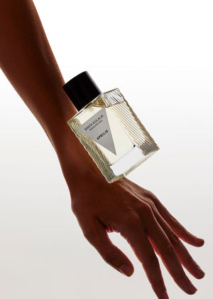 Perfume bottle held by a hand on a white background