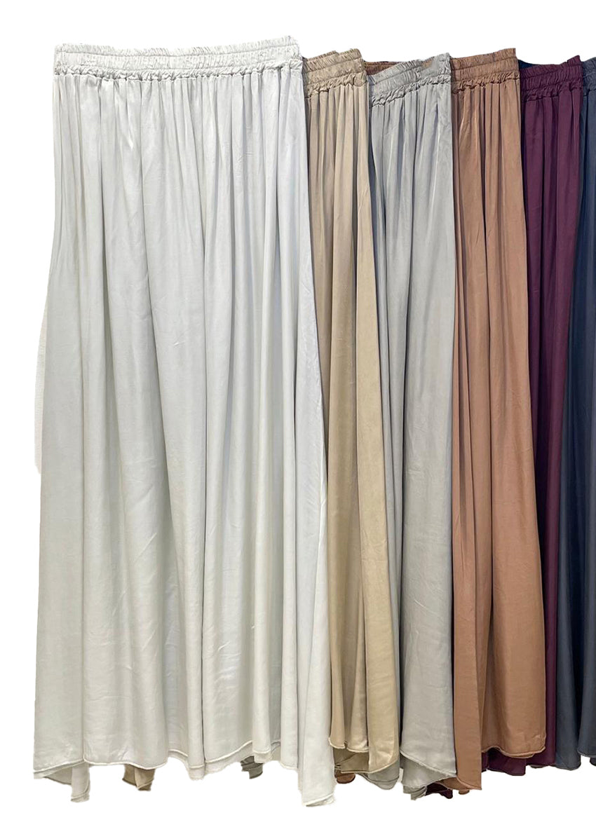 Set of five long skirts in different colors on a white background