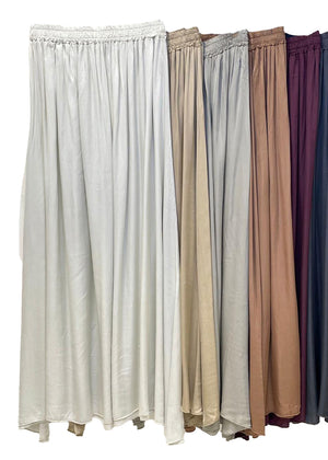 Set of five long skirts in different colors on a white background
