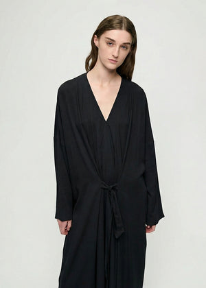 Woman wearing a black dress against a white background