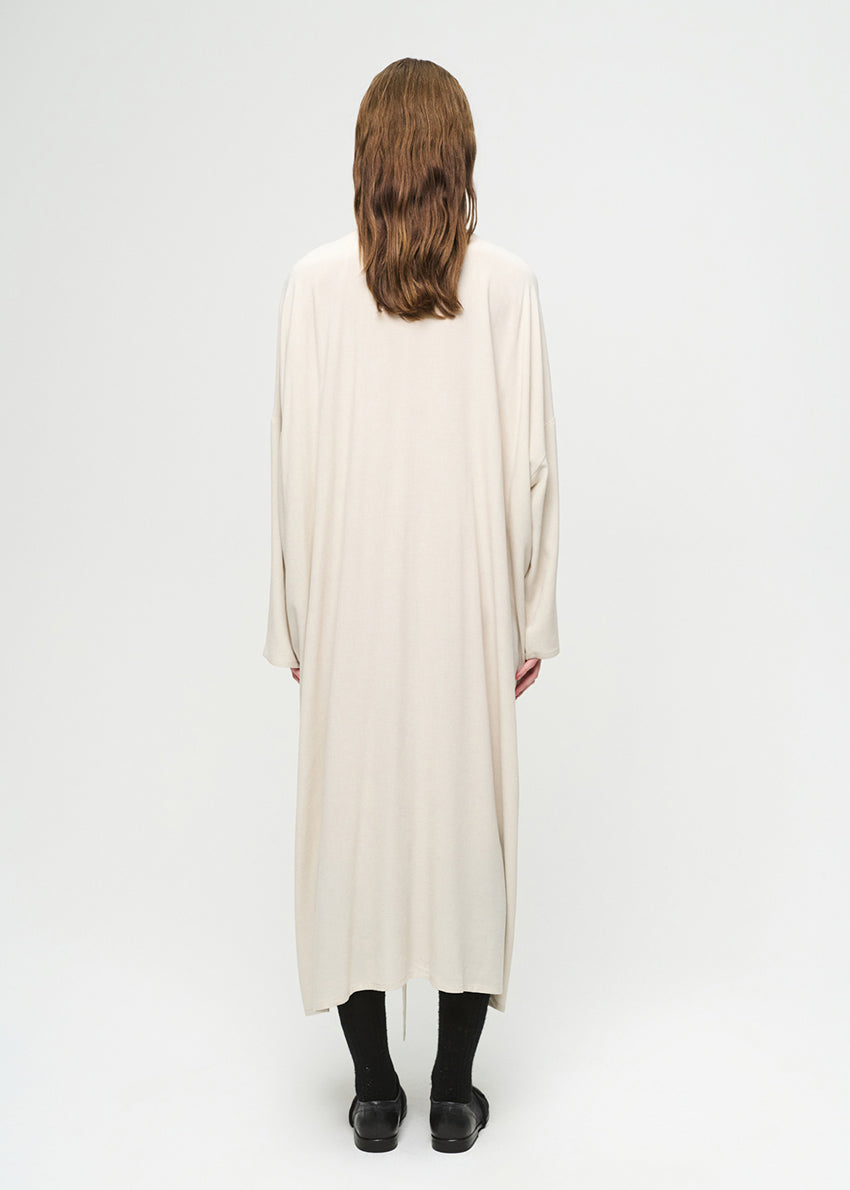 Person wearing a long, light-colored dress on a white background