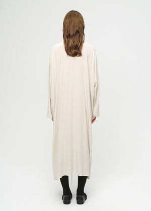 Person wearing a long, light-colored dress on a white background