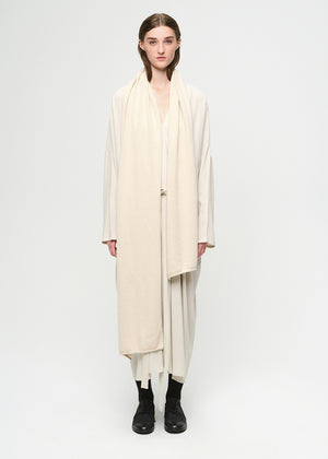 Person wearing a long beige scarf and dress on a white background