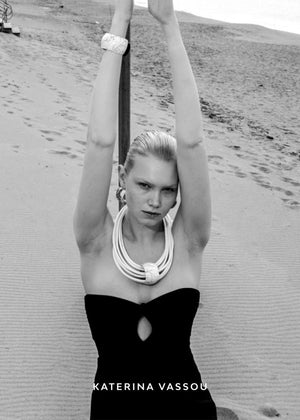 A white, multi-layered choker necklace with a cylindrical pendant and dimgray details, designed by Katerina Vassou.