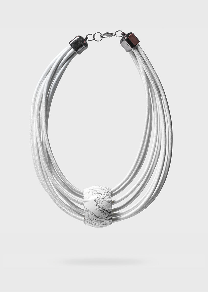 A white, multi-layered choker necklace with a cylindrical pendant and dimgray details, designed by Katerina Vassou.