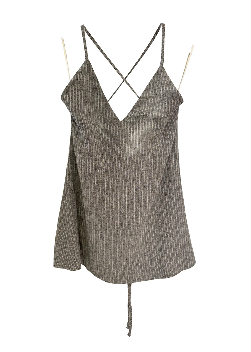Woman wearing a black sleeveless top and white patterned skirt on a white background