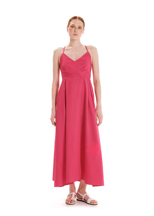 A model wearing a backless, asymmetric pink dress with a 'V' neck, side pockets, and an asymmetrical hemline.