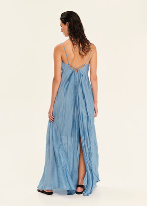 Woman wearing a blue dress with a slit on a white background