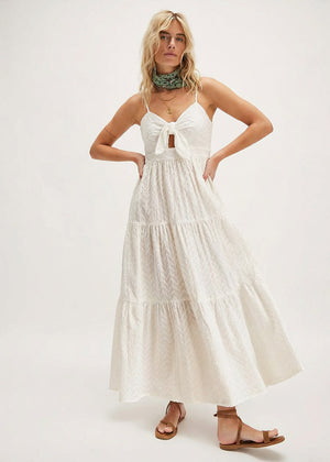 Woman wearing a white tiered dress on a white background