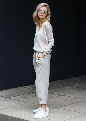 The sweater showcases a deep V-neckline at the front and back, adding a touch of sophistication to its minimalistic design.