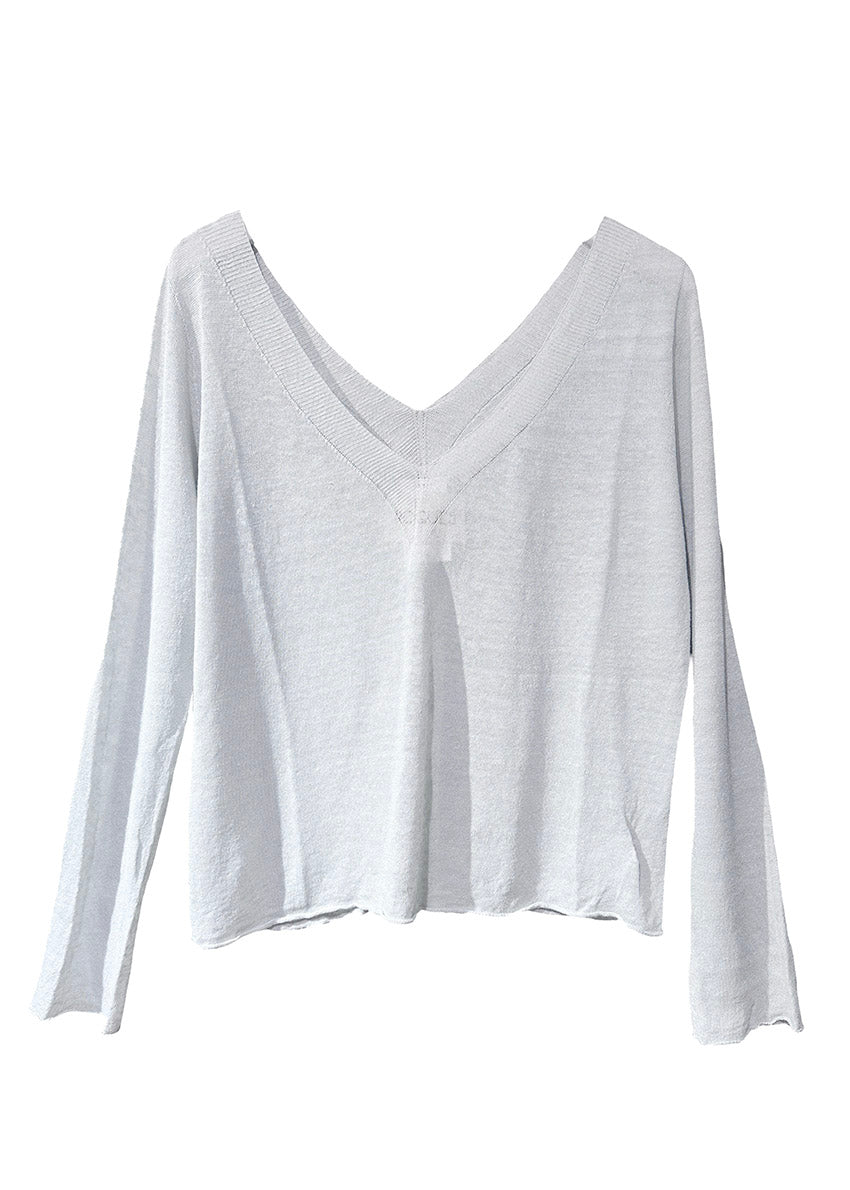 The sweater showcases a deep V-neckline at the front and back, adding a touch of sophistication to its minimalistic design.