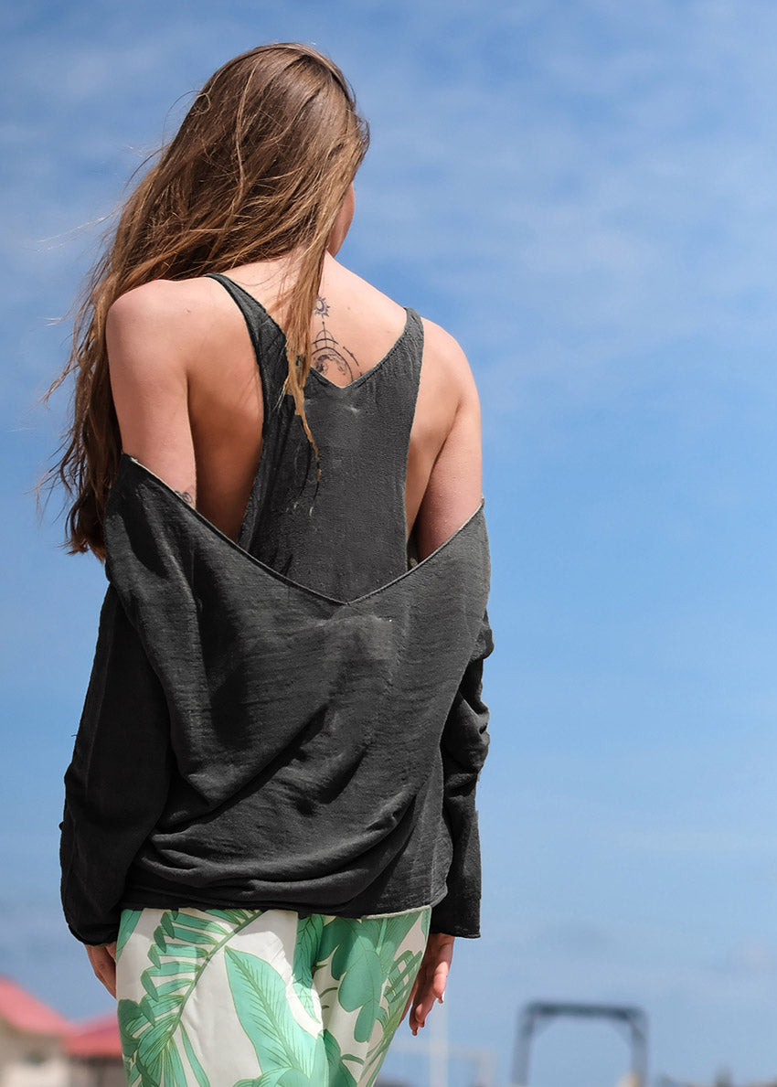 A black sleeveless top with a wide V-neck front neckline and open halter back. The top is displayed on a white background with a visible brand tag.