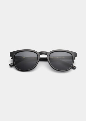 Black sunglasses with a brand logo on a light gray background