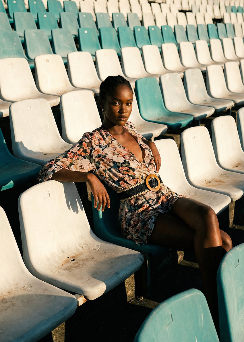 Woman sitting in a stadium with green and white seats