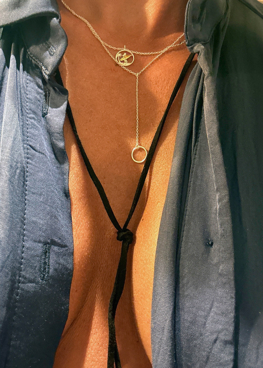 A fashionable necklace from the 'birds' collection, featuring a gold and silver color contrast with a bird-shaped pendant and a large circular charm.