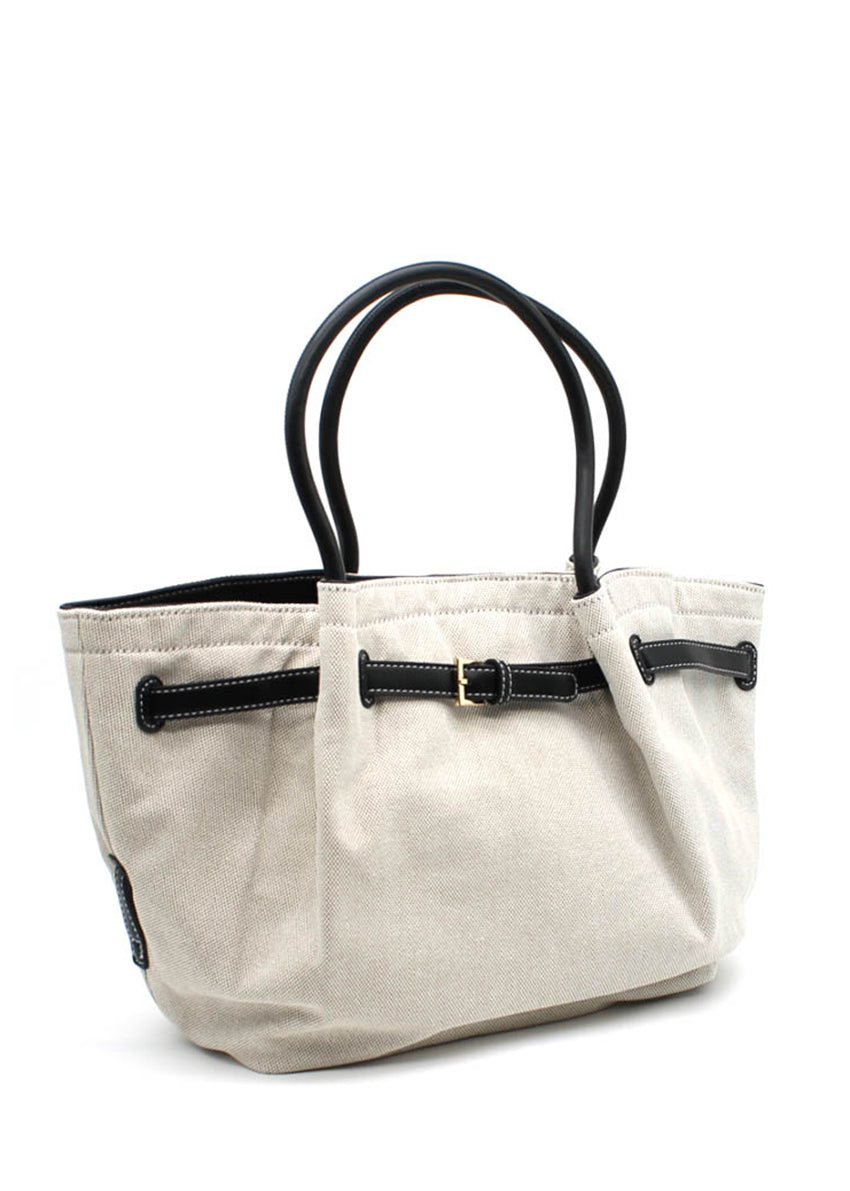 Light beige canvas tote bag with black leather handles and buckle accents. A spacious and durable design perfect for daily use