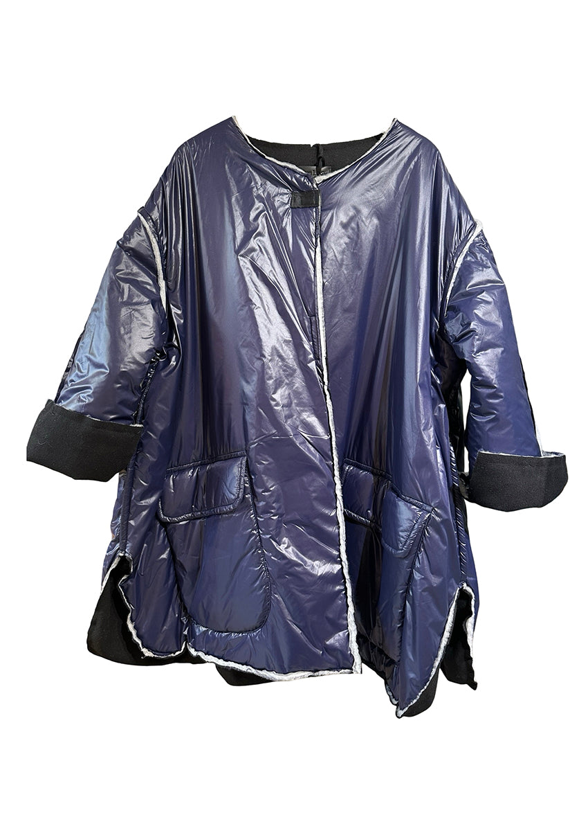 A double-faced jacket with a black front and blue fleece side, featuring pockets and a front closure with adhesive tape.