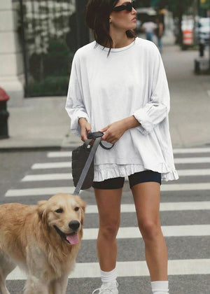 Woman walking a dog on a leash in an urban setting