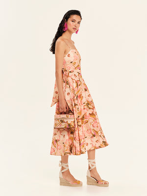 Woman wearing a floral strapless dress on a white background