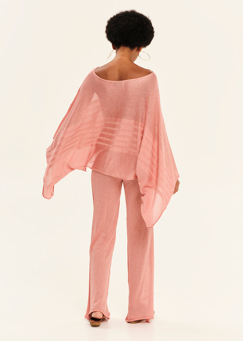 Person wearing a pink outfit with a flowing top and pants on a white background