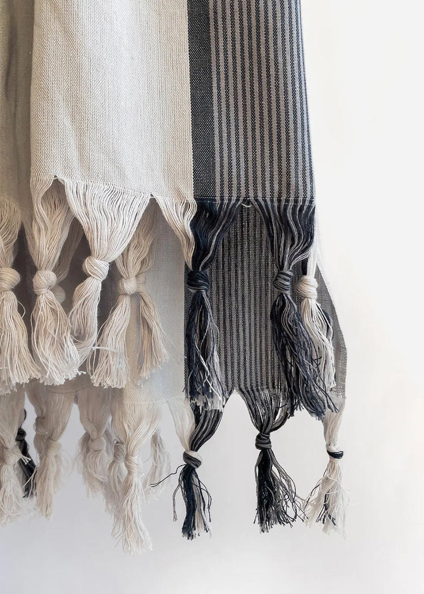 Crafted from 100% organic cotton, its natural softness is evident from the first touch. Featuring a light gray base with subtle pale dark blue stripes, this towel combines style and functionality effortlessly