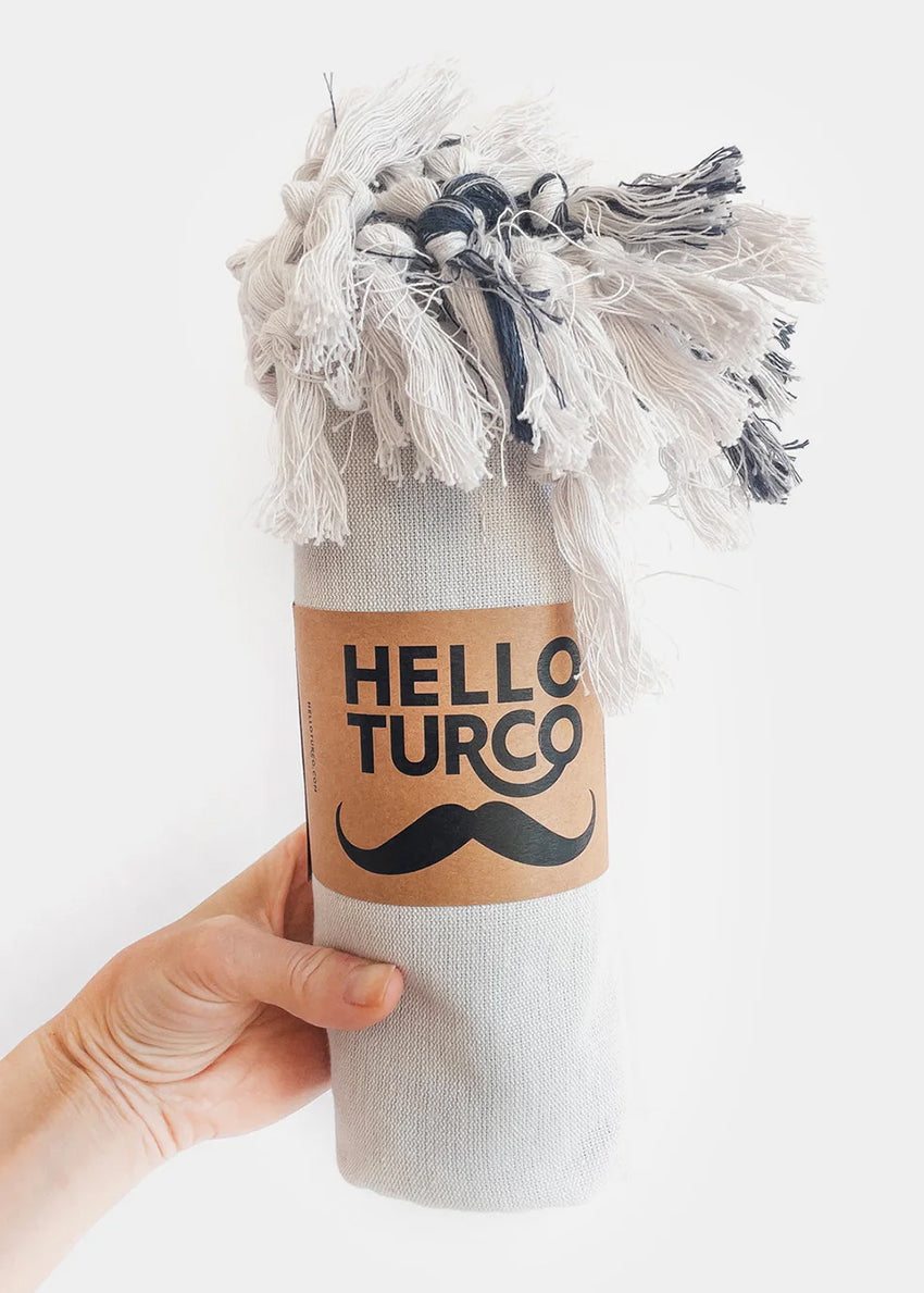 Crafted from 100% organic cotton, its natural softness is evident from the first touch. Featuring a light gray base with subtle pale dark blue stripes, this towel combines style and functionality effortlessly