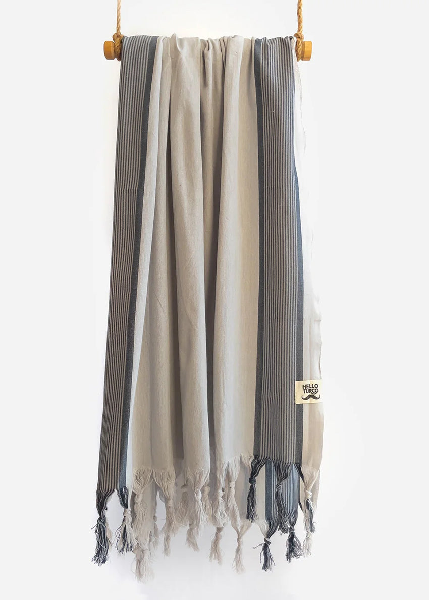 Crafted from 100% organic cotton, its natural softness is evident from the first touch. Featuring a light gray base with subtle pale dark blue stripes, this towel combines style and functionality effortlessly