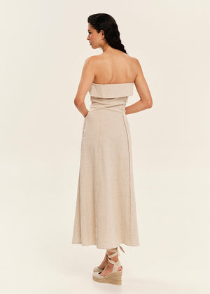 Woman wearing a strapless beige dress on a plain background