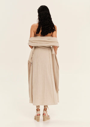 Woman wearing a beige off-shoulder dress on a white background