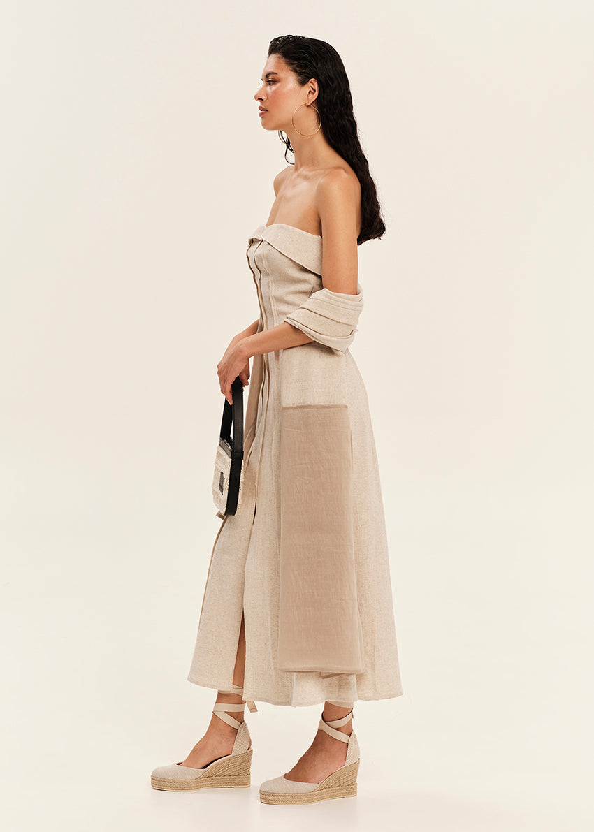 Woman wearing a beige strapless dress with a white background